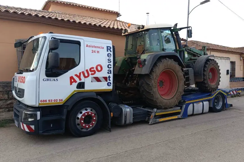 Grúa de auxilio de Ayuso con un tractor cargado sobre la plataforma.