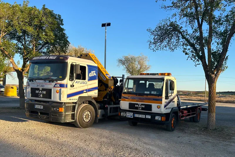 Camión grúa de Ayuso remolcando otro camión averiado en la carretera.